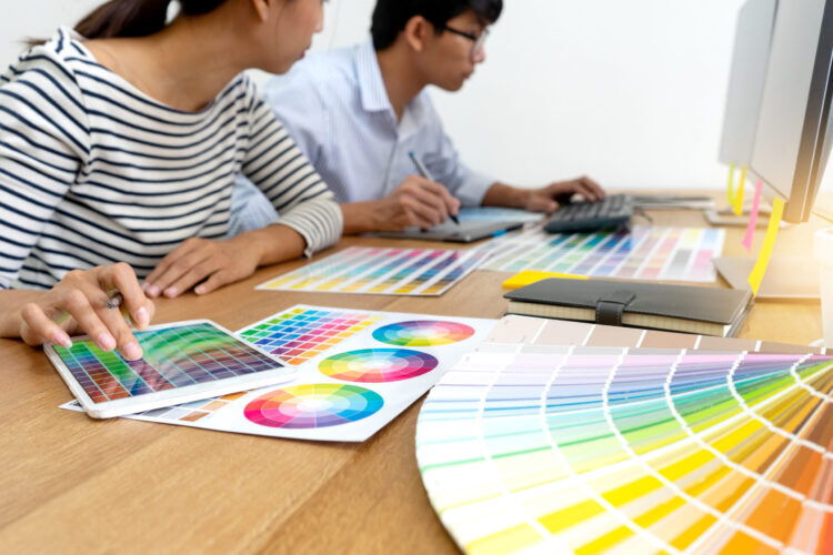 Team work for graphic design working on wood table with computer tablet electronic pen and color chart,